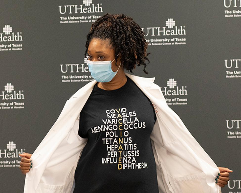 Jeffeea n食道,MD,骄傲地展示她的衬衫促进疫苗挽救了无数的生命。(图片由科迪责任,UTHealth)