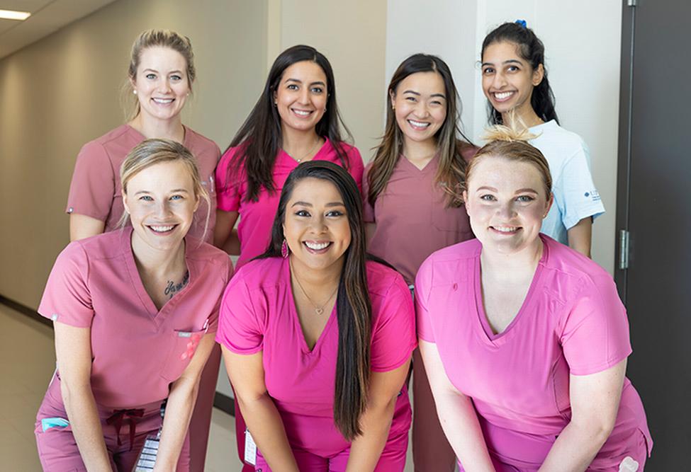UTHealth休斯顿牙科学院TAWD分会的官员穿着粉红色的磨片，以表彰全国乳腺癌宣传月。