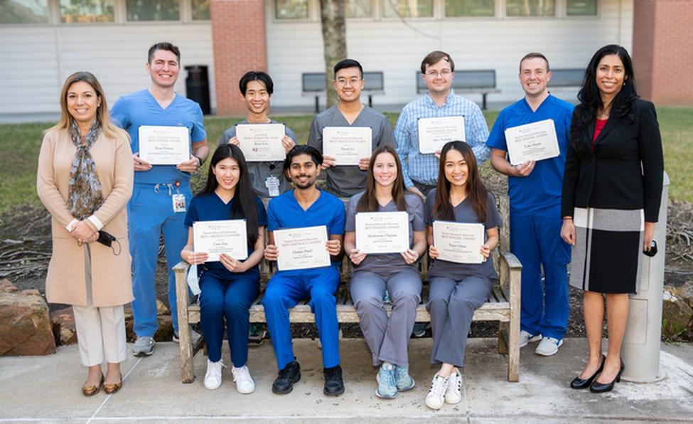 Student Research Showcase award winners gather for a group photo with their certificates in the courtyard of the Denton A. Cooley, MD, and Ralph C. Cooley, DDS, University Life Center.