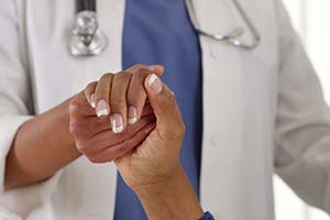 image of doctor holding hand of patient - diverse